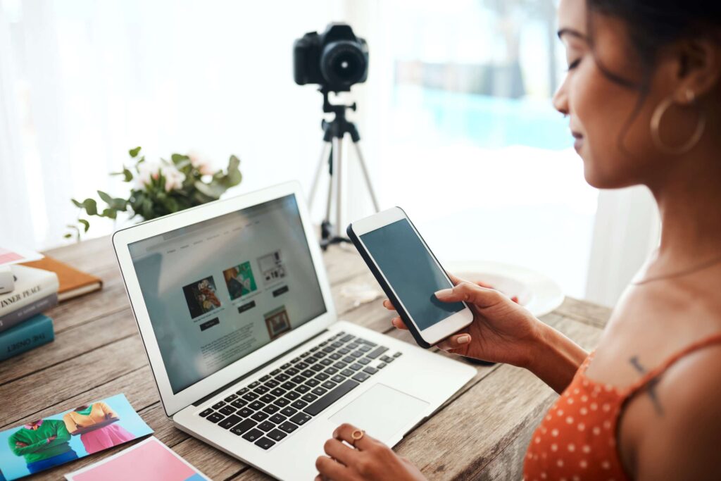 Woman checking her phone while being on laptop